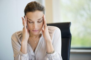 Close-up of a businesswoman suffering from a headache in an office