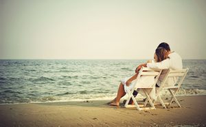 Romantic_Couple_Seating_on_Beach_Wallpaper_Download